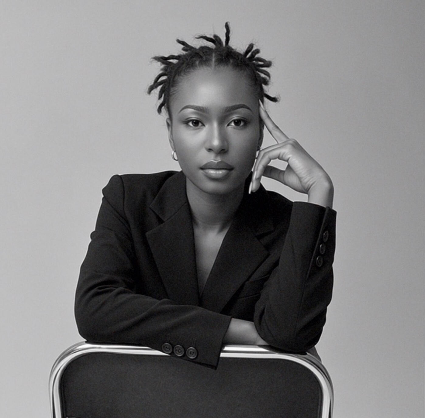 Lehbie Rae — Illustrator & Visual Storyteller Black and white portrait of Lehbie Rae, French illustrator and visual storyteller, seated in a black suit.